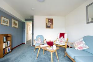 a living room with a couch and chairs and a table at KATHERINES COURT - Spacious Apartment with Rolling Hill Views in Kendal