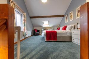 a bedroom with a large bed with red pillows at KATHERINES COURT - Spacious Apartment with Rolling Hill Views in Kendal