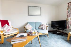 a living room with a blue couch and a coffee table at KATHERINES COURT - Spacious Apartment with Rolling Hill Views in Kendal