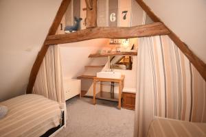 a small attic room with a bed and a desk at Villa de charme entre deux baies in Rue
