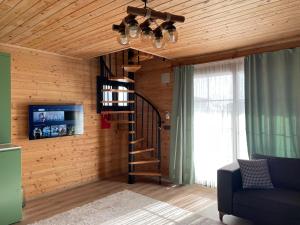 a living room with a spiral staircase and a tv at Demre Lukka Bungalow in Demre