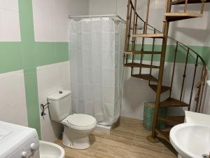 a bathroom with a toilet and a shower curtain at White-Moon in Baena
