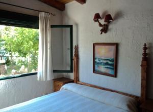 a bedroom with a bed and a mirror and a window at Casa rural Ribera de Salobre in Salobre