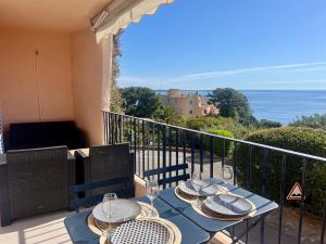 a table on a balcony with a view of the ocean at Residence port la galere in Théoule-sur-Mer