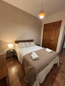 a bedroom with a large bed with two towels on it at REFUGiO MAGiCO in Herencia +45 photos