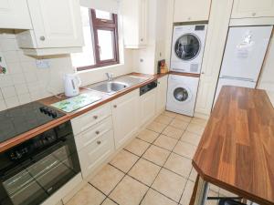 a kitchen with a sink and a washing machine at Daffodil Cottage in Grange +13 photos