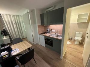 a kitchen with a table and a sink and a toilet at Le D'Artagnan - App 11 - Balcon in Cazaubon