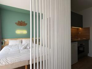 a bedroom with a bed with a striped wall at Le D'Artagnan - App 11 - Balcon in Cazaubon