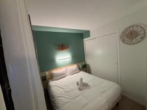 a small bed with a cross on top of it at Le D'Artagnan - App 11 - Balcon in Cazaubon +8 photos