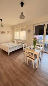 a bedroom with a bed and a table and chairs at TRIO apartment in Piešťany