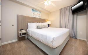a hotel room with a large bed and a television at Phoenix All Suites West Hotel in Gulf Shores