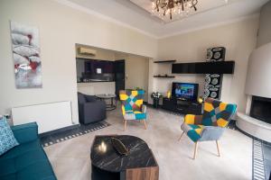 a living room with a couch and chairs and a tv at Koni Guesthouse in Kos