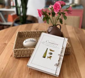 a book sitting on a table next to a vase with a flower at Casa 1895- where history meets comfort in Žalec
