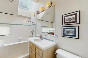 a bathroom with a sink and a toilet and a mirror at One Eyed Jack's Retreat in Sea Ranch +13 photos