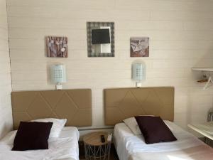 - 2 lits dans une chambre avec 2 lampes sur le mur dans l'établissement Les Chambres de la Gare, à Noyers-sur-Cher 21 autres photos