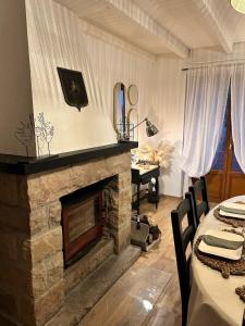 a living room with a stone fireplace and a table with chairs at La maison du Distillateur in Plurien