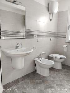 a white bathroom with a sink and a toilet at Family home in Donigala Fenughedu +8 photos