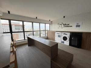 a large room with a desk and a microwave at Max Derby - Studios no Centro do Recife por Yolo in Recife
