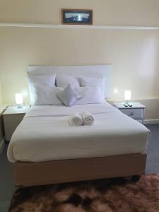 a bedroom with a large bed with two towels on it at Faranie Guesthouse in Oudtshoorn