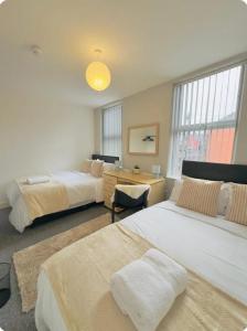 a bedroom with two beds and a desk and window at Room 4 Shared House in L6 in Liverpool