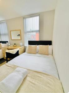 a bedroom with a large white bed and a desk at Room 4 Shared House in L6 in Liverpool