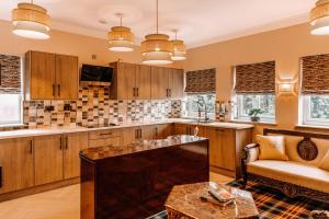 a kitchen with wooden cabinets and a couch and a table at Domo Boutique Hotel Birmingham in Birmingham