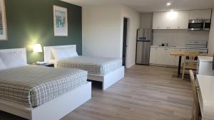 a hotel room with two beds and a kitchen at Riverside Inn in Wabasca