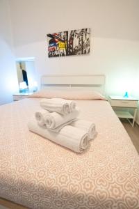 a bed with three towels on it with a picture at Disiu Case Vacanza in Balestrate