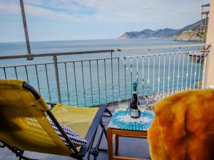 balkon ze stołem i butelką wina w obiekcie La Lampara Sea View Terrace Apartment w mieście Manarola +37 zdjęć