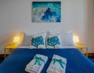 niebieskie łóżko z dwoma ręcznikami na górze w obiekcie La Lampara Sea View Terrace Apartment w mieście Manarola