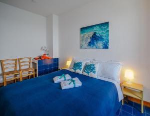 sypialnia z niebieskim łóżkiem i 2 ręcznikami w obiekcie La Lampara Sea View Terrace Apartment w mieście Manarola