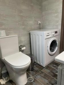 a bathroom with a toilet and a washing machine at Center Twin Apartments - 2 in Chios