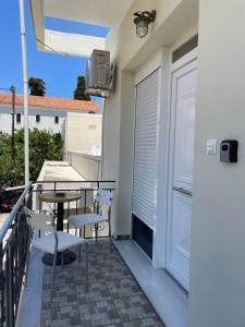 a balcony with a table and chairs and a door at Center Twin Apartments - 2 in Chios