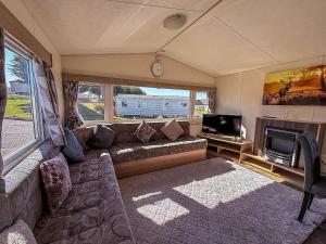 BenacreにあるHomely Caravan At Kessingland Beach Holiday Park, Suffolk Ref 90040Bcのリビングルーム(ソファ、テレビ付)