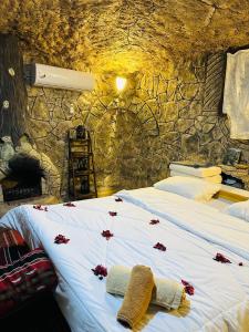 una camera da letto con un letto con fiori rossi di منتزه واكواخ كركوش a Ajloun Altre 7 foto