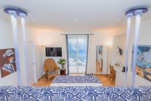 ein Schlafzimmer mit einem Bett und einem Fernseher in der Unterkunft Five Positano - Dimora D'Arte in Positano