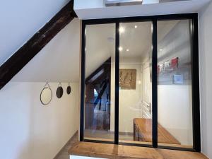a room with glass doors in a attic at La Cabane de la Rance - appartement 3 personnes in Lanvallay