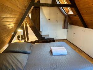 a bedroom with a large bed in a attic at La Cabane de la Rance - appartement 3 personnes in Lanvallay