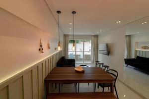 ein Esszimmer mit einem Holztisch und Stühlen in der Unterkunft Apartamento com 2 quartos a 50 metros da praia in Porto De Galinhas