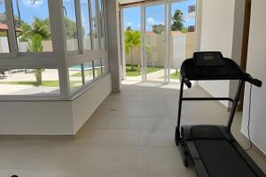 ein Laufband in einem Zimmer mit einem großen Fenster in der Unterkunft Apartamento com 2 quartos a 50 metros da praia in Porto De Galinhas