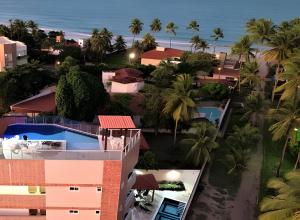 eine Luftaufnahme eines Resorts mit Palmen und dem Meer in der Unterkunft Apartamento com 2 quartos a 50 metros da praia in Porto De Galinhas