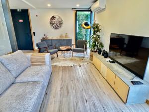 a living room with a couch and a flat screen tv at Square house in Funchal