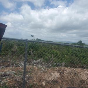 een kettinghek met een veld op de achtergrond bij RJs Ranch in Ocho Rios