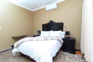 a bedroom with a large bed and a black dresser at De Luna Apartments in Bethlehem