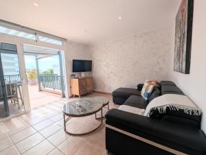 a living room with a black couch and a tv at Luxury & Panorama Apartment in Costa de Adeje