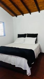 a bedroom with a large bed with black and white sheets at Cabaña Alcalá Campestre in Pinchote