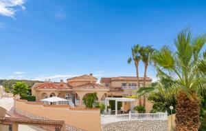 a large house with palm trees in front of it at Casa Kiga in Ciudad Quesada