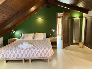 a bedroom with a large bed with a green wall at El Patio de Toledo in Toledo