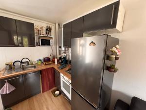 a small kitchen with a stainless steel refrigerator at Appartement à louer in Longueil-Sainte-Marie