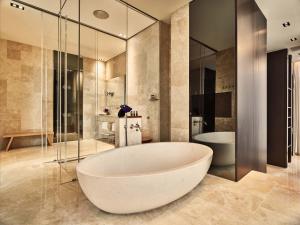 a large bathroom with a tub and a shower at Conservatorium Hotel in Amsterdam